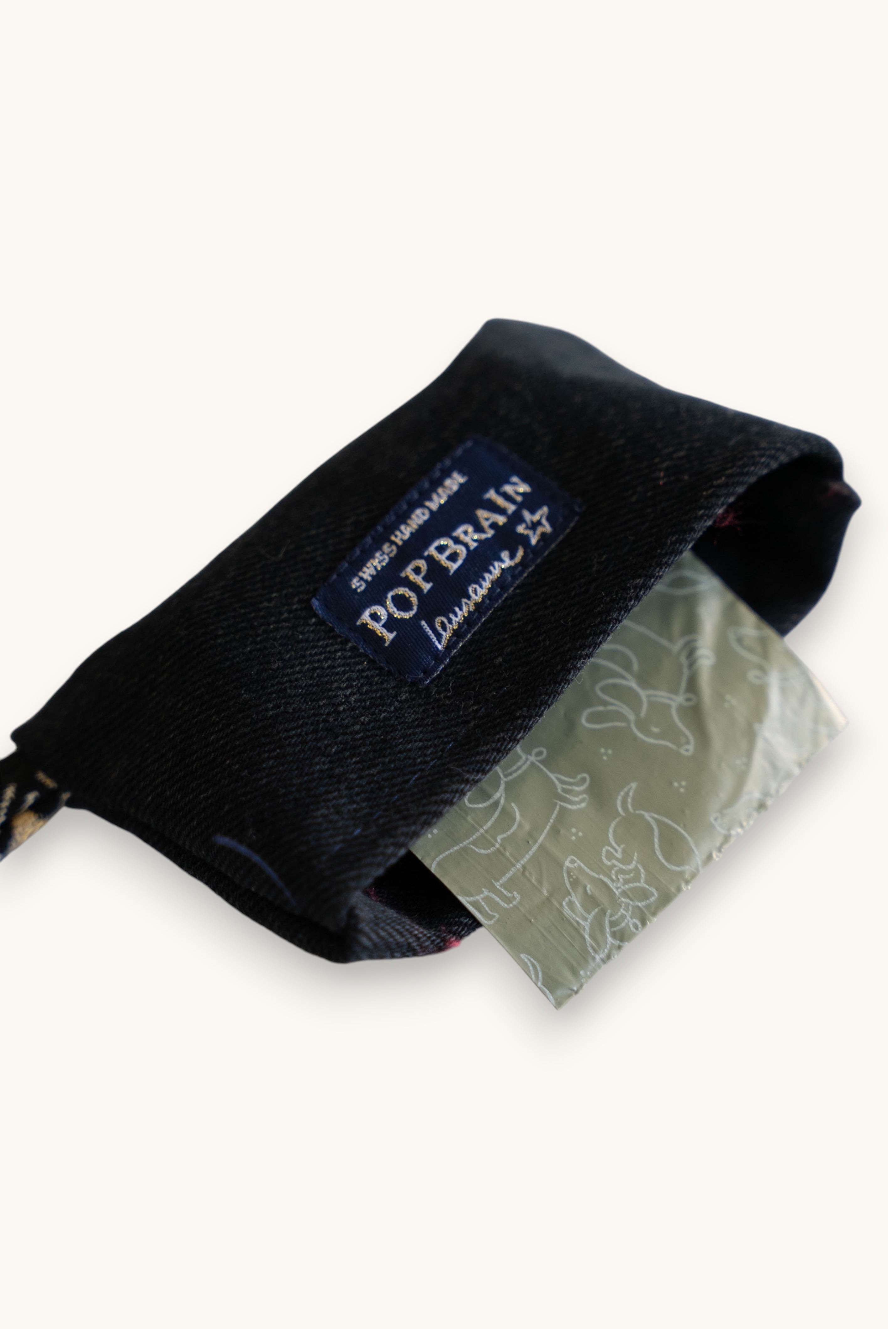 Popbrain black faux leather dog waste bag dispenser with a branded label, handmade in Switzerland.