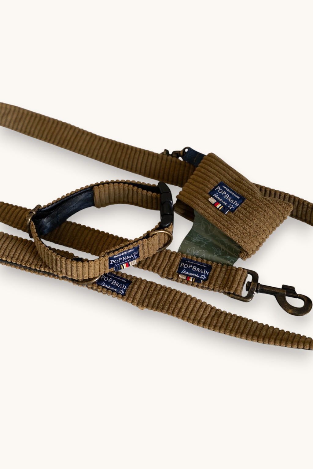Popbrain Safari collection set featuring a camel corduroy dog collar, leash, and waste bag holder with bronze hardware.
