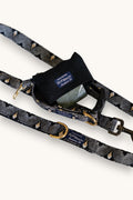 Popbrain Tokyo collection black faux leather dog waste bag holder with gold hardware attached to a patterned leash