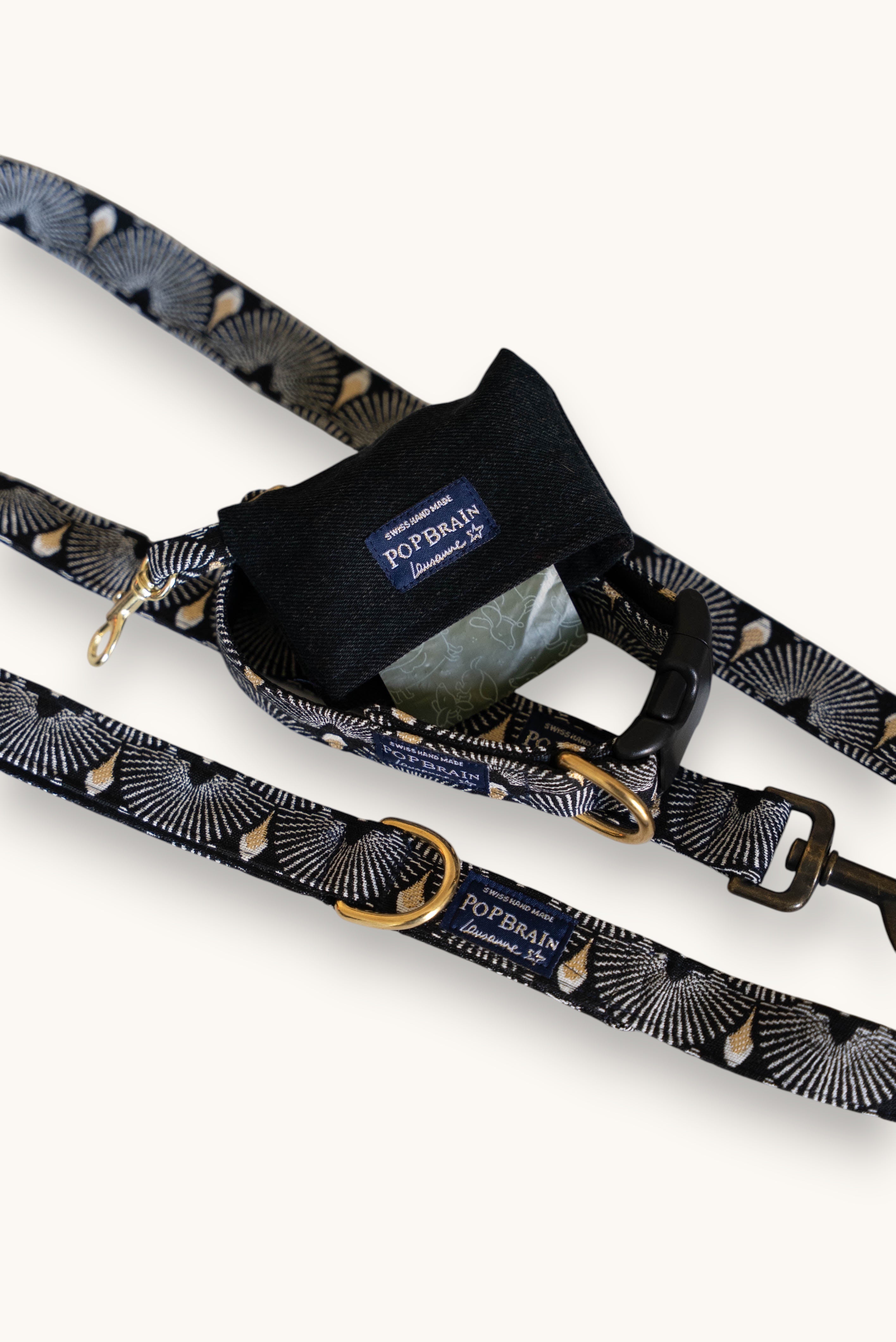 Popbrain Tokyo collection black faux leather dog waste bag holder with gold hardware attached to a patterned leash